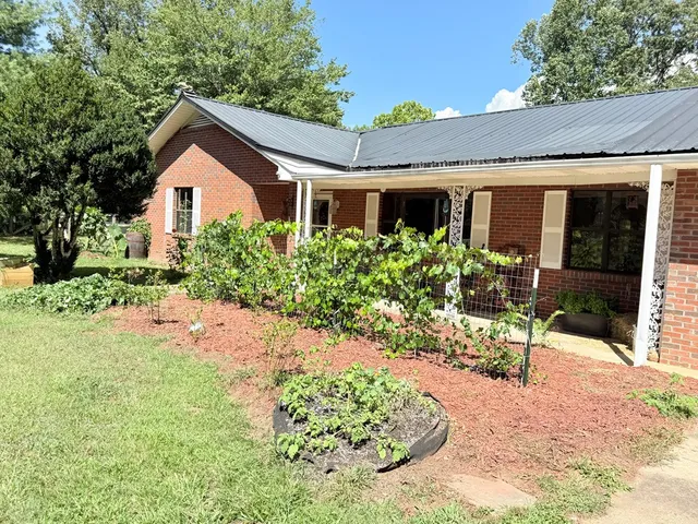 a view of a house with yard and sitting area