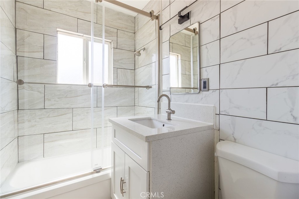 5923 Tyler Street Riverside, CA 92503 - Photo 16 of 19 a bathroom with a sink and mirror with bathtub