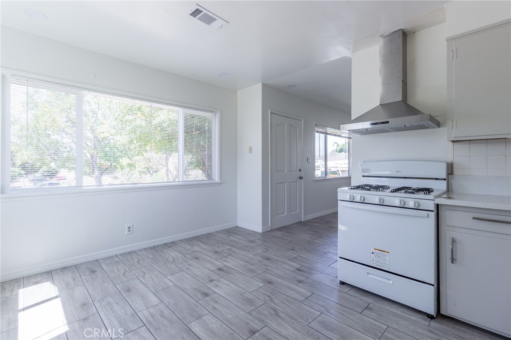 5923 Tyler Street Riverside, CA 92503 - Photo 8 of 19 a kitchen with a stove wooden floor and window