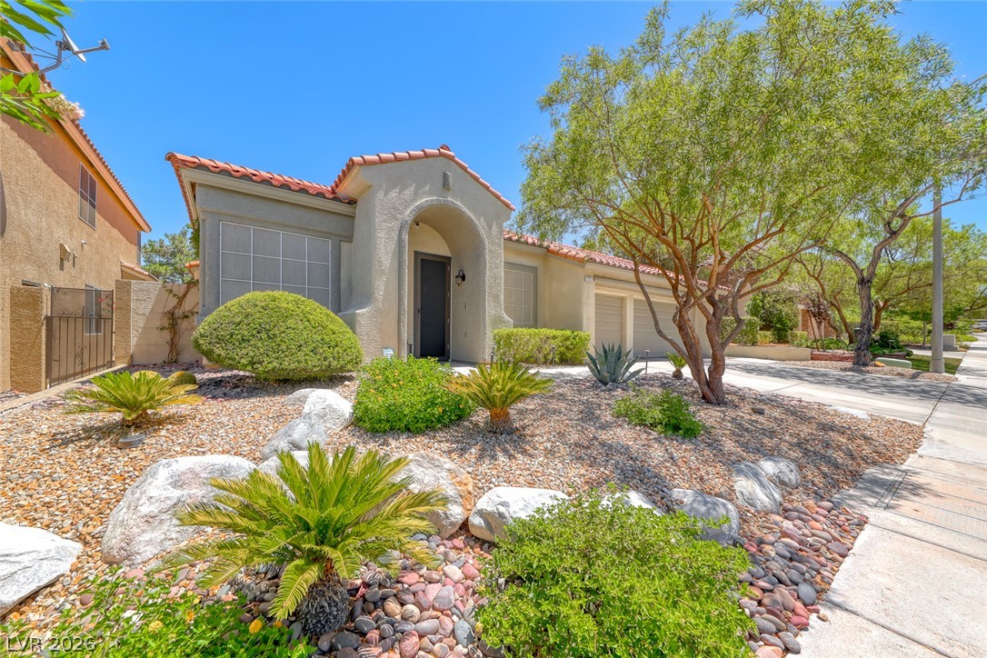 2122 Mooreview Street Henderson, NV 89012 - Photo 2 of 44 A well-maintained desert landscape frames this welcoming stucco home with a tile roof.