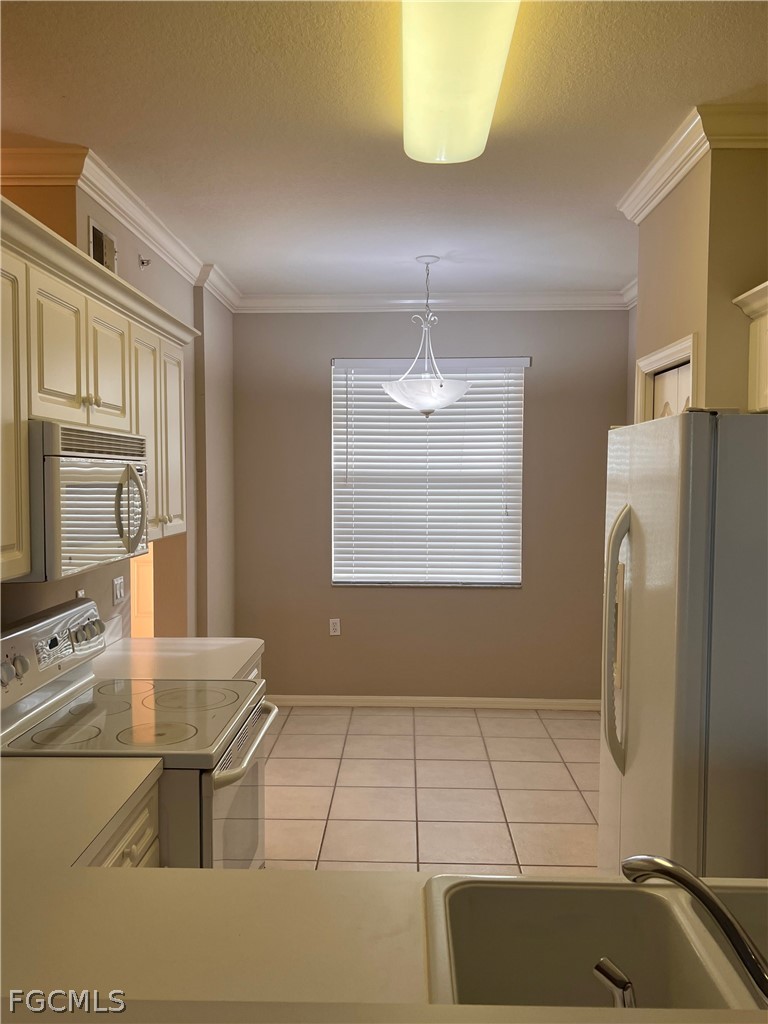 8570 Kingbird Loop, Unit 535 Estero, FL 33967 - Photo 2 of 14 a kitchen with stainless steel appliances kitchen island granite countertop a refrigerator a stove a sink and dishwasher
