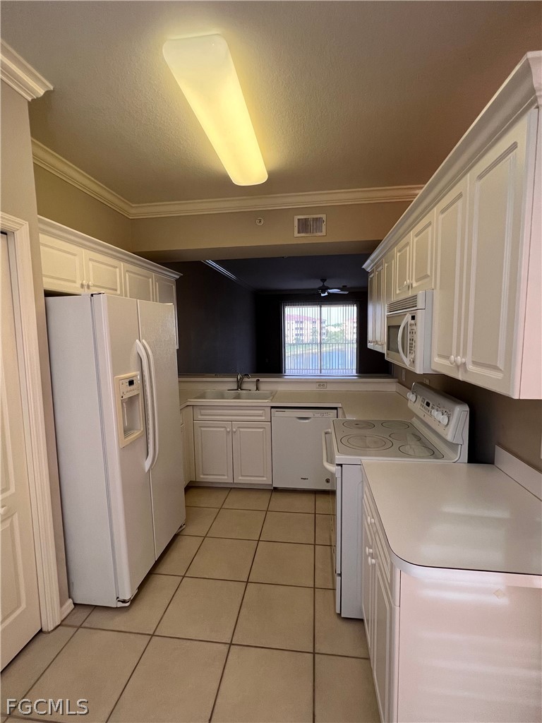 8570 Kingbird Loop, Unit 535 Estero, FL 33967 - Photo 3 of 14 a kitchen with a refrigerator sink and cabinets