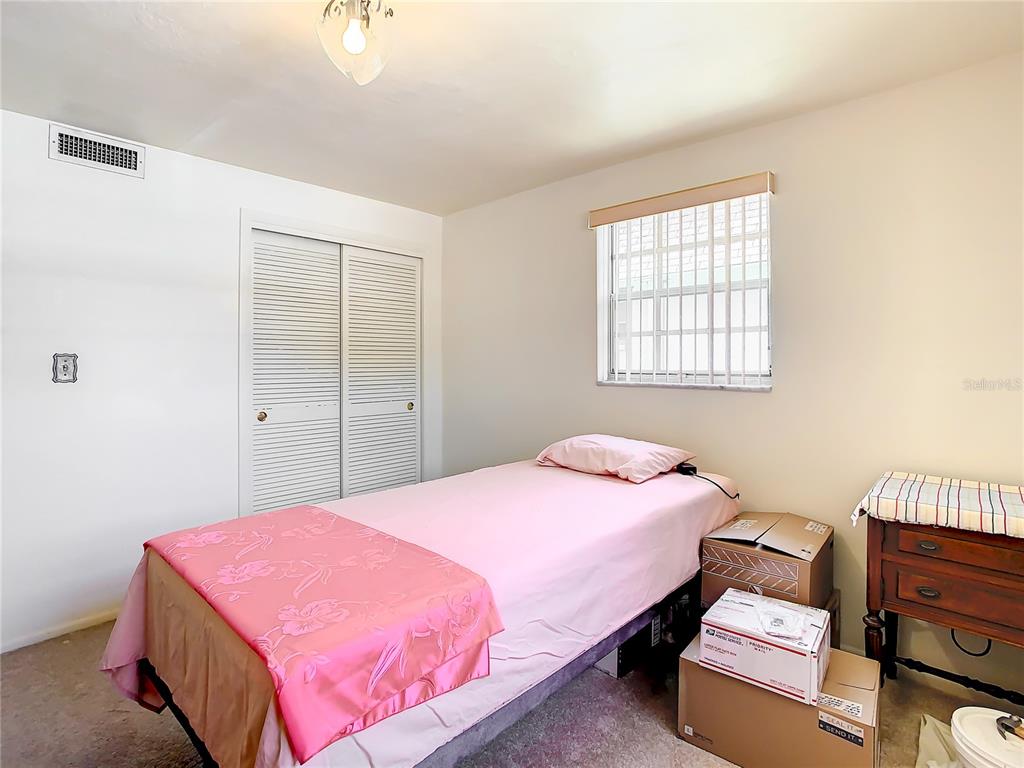 4230 Redcliff Place, Unit 4230 New Port Richey, FL 34652 - Photo 21 of 42 a bedroom with a bed and wooden floor