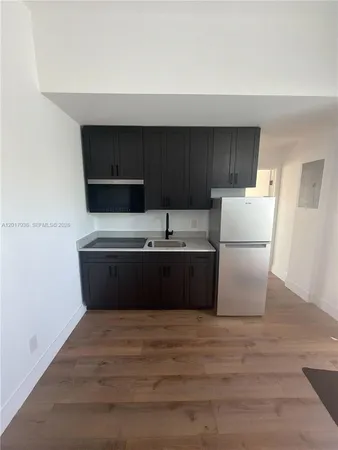 a room with a sink and a refrigerator