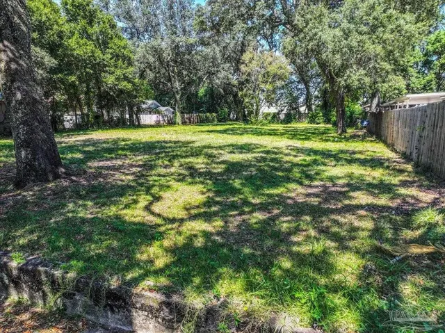a view of a grassy field with trees in the background