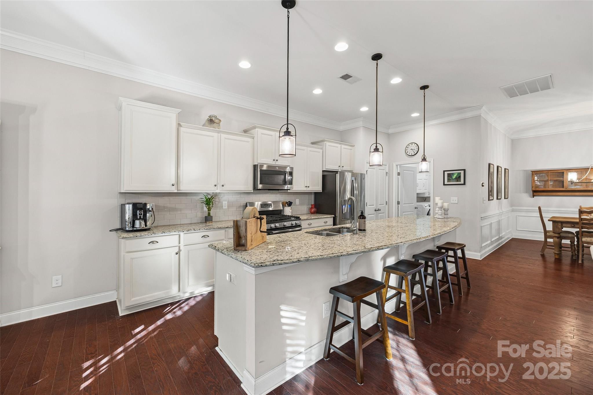 1541 Hedge Apple Road Clover, SC 29710 - Photo 13 of 48 a kitchen with stainless steel appliances kitchen island granite countertop a stove a sink a dining table and chairs with wooden floor