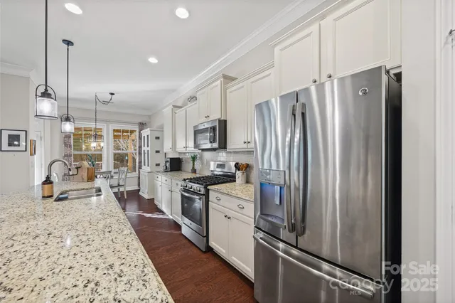 a kitchen with stainless steel appliances granite countertop a refrigerator stove and sink