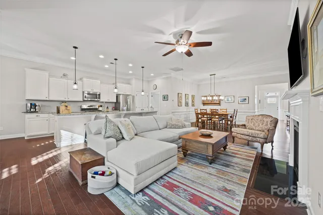 a living room with furniture and a view of kitchen