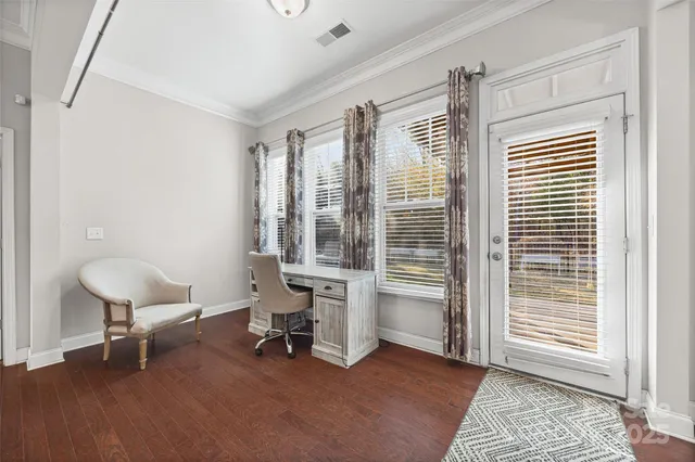 a view of a workspace with furniture and a window