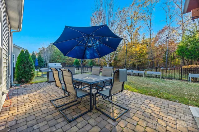 a view of a backyard with table and chairs under an umbrella