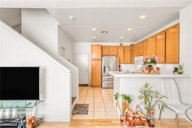 a living room with stainless steel appliances furniture and a flat screen tv