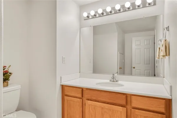 a bathroom with a sink vanity granite and toilet