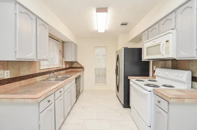 a kitchen with stainless steel appliances a refrigerator and a stove
