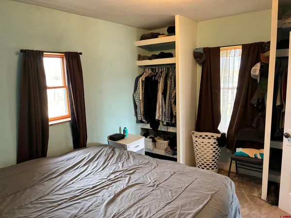 a bedroom with a bed next to a window
