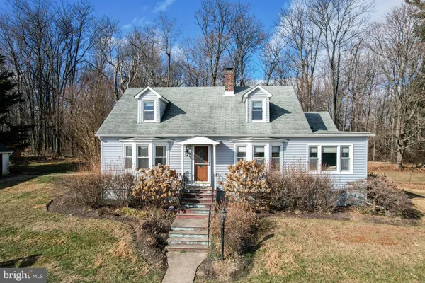 a front view of house with yard and trees around