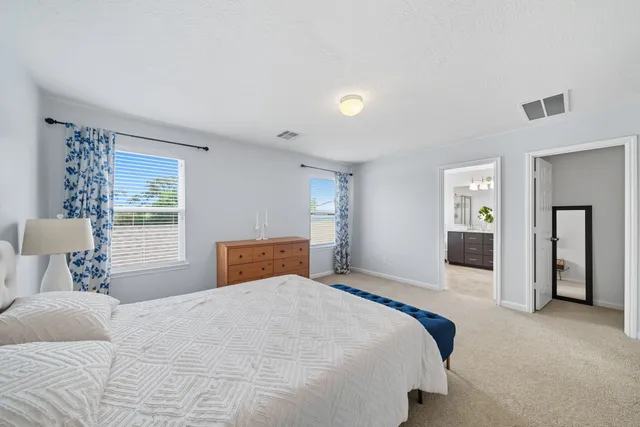 a bedroom with a large bed and dresser