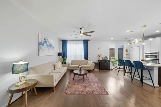 a living room with furniture and a wooden floor