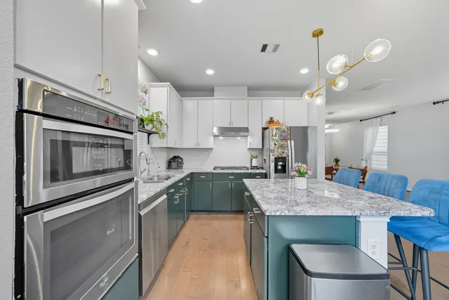 a kitchen with kitchen island a table and chairs in it