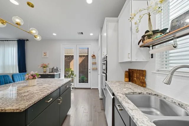 a kitchen with stainless steel appliances granite countertop a sink a stove and a refrigerator