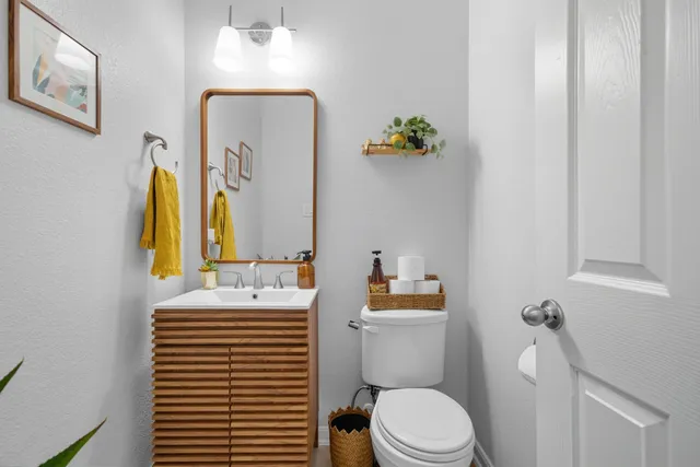 a bathroom with a sink a toilet and mirror