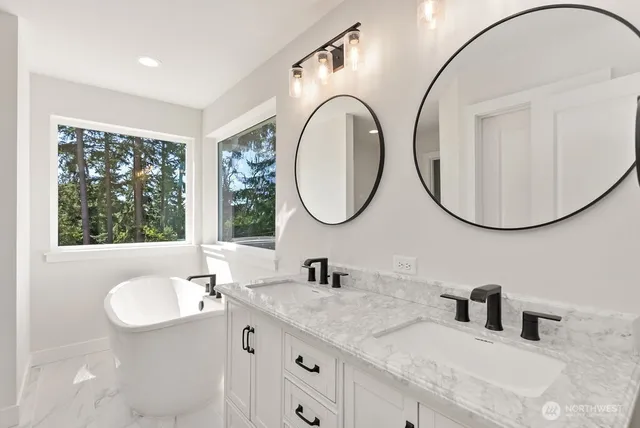 a bathroom with a white tub a sink and a window