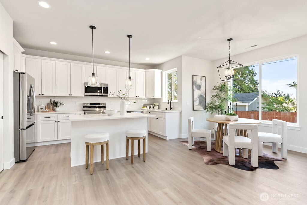 1720 South Tyler Street Tacoma, WA 98405 - Photo 8 of 14 a kitchen with stainless steel appliances kitchen island granite countertop a table chairs and a wooden floor