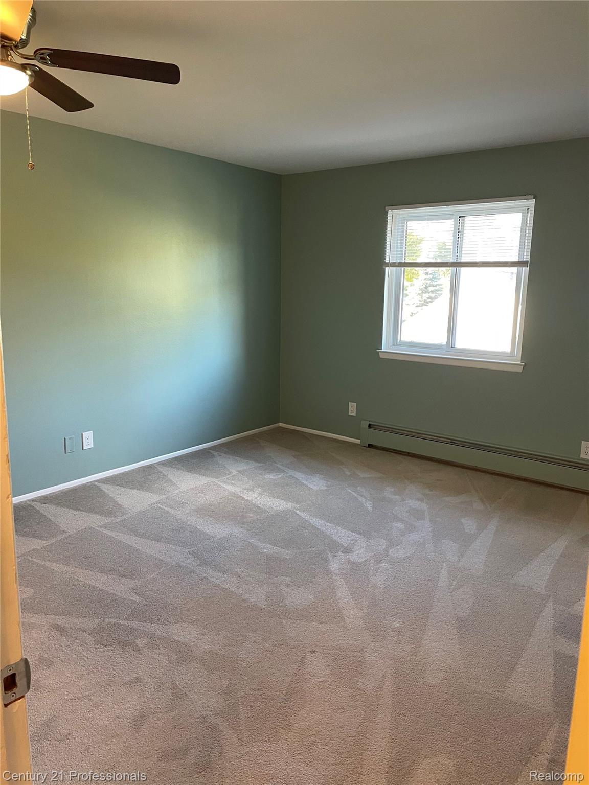 810 Plate Street, Unit 205 Rochester, MI 48307 - Photo 11 of 16 Carpeted room with a ceiling fan, a window, and baseboard heating