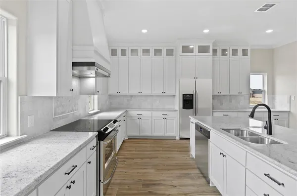 a kitchen with stainless steel appliances granite countertop a sink and a refrigerator