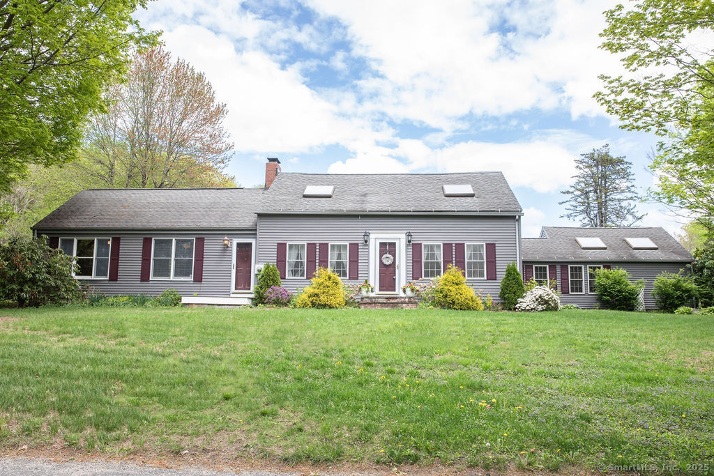 a view of a house with a big yard and potted plants