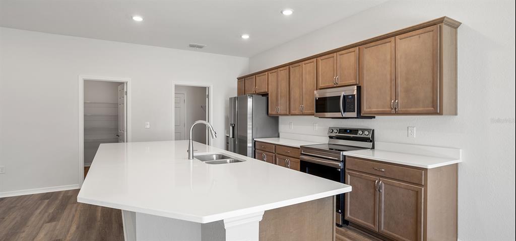 7550 Southwest 107th Lane Ocala, FL 34476 - Photo 7 of 22 a kitchen with stainless steel appliances a stove microwave and sink