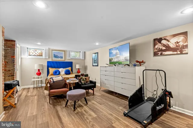 a view of a backyard with table and chairs potted plants and large tree