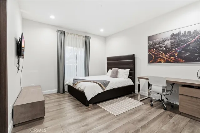 a bedroom with a bed and wooden floor