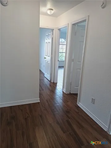 a view of a hallway with wooden floor