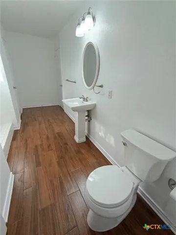 a bathroom with a toilet and a mirror