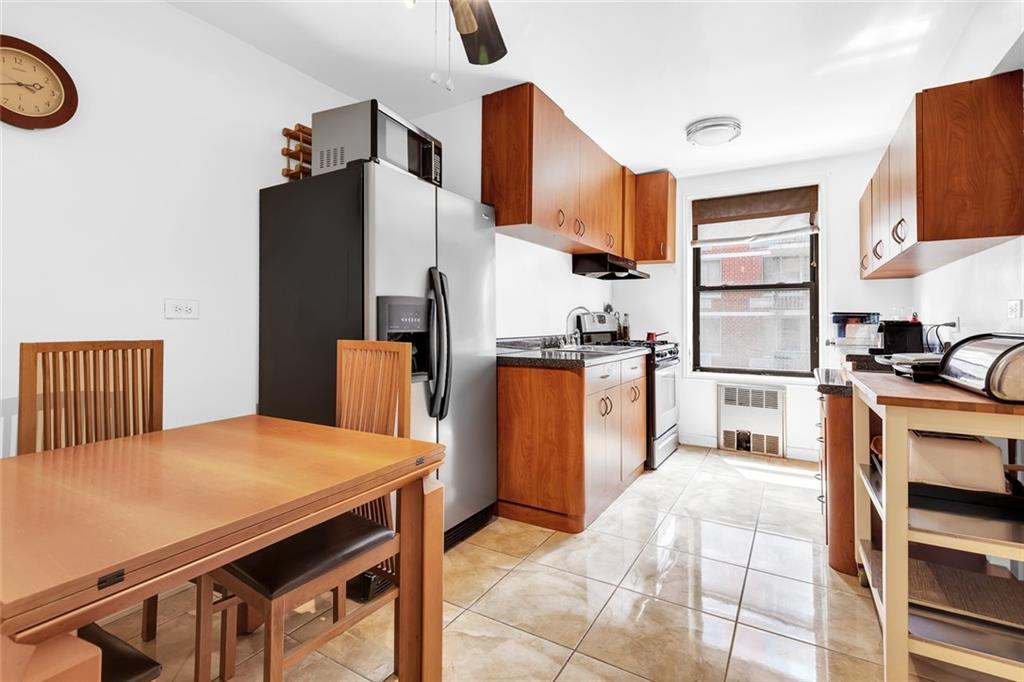 9511 Shore Road, Unit 313 Brooklyn, NY 11209 - Photo 4 of 11 a kitchen with stainless steel appliances refrigerator stove microwave and cabinets