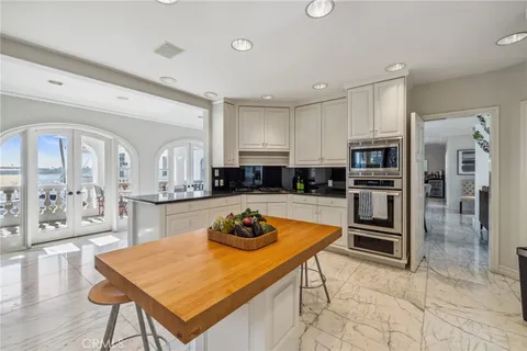 a kitchen with granite countertop a sink and white cabinets