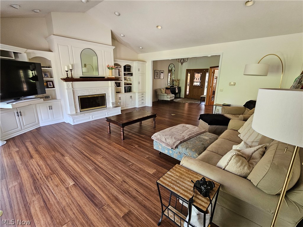 2363 Tabor Ridge Road Northeast New Philadelphia, OH 44663 - Photo 22 of 42 Spacious living area featuring wood-finish flooring, a white fireplace with a dark wood mantel, and integrated built-in cabinetry