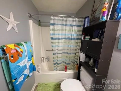 a bathroom with a toilet and shower curtain