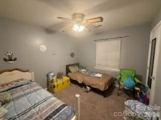 a bedroom with two beds and chandelier