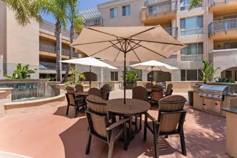 a view of a patio with a dining table and chairs under an umbrella