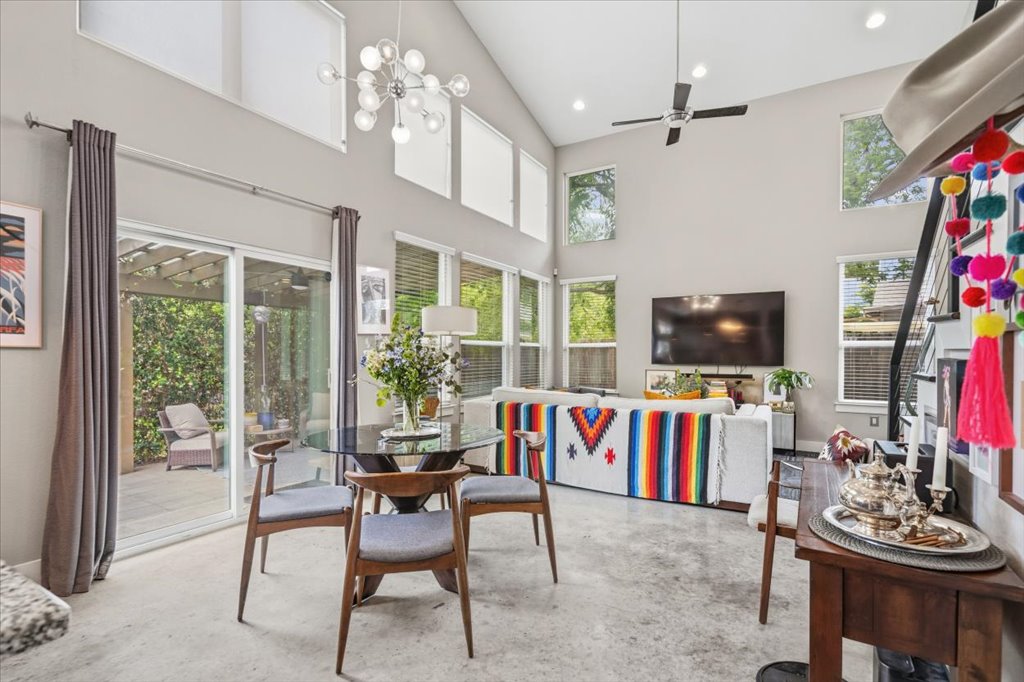 1800 Webberville Road, Unit B Austin, TX 78721 - Photo 9 of 30 Vaulted ceilings with high windows and a contemporary chandelier illuminate this expansive living space