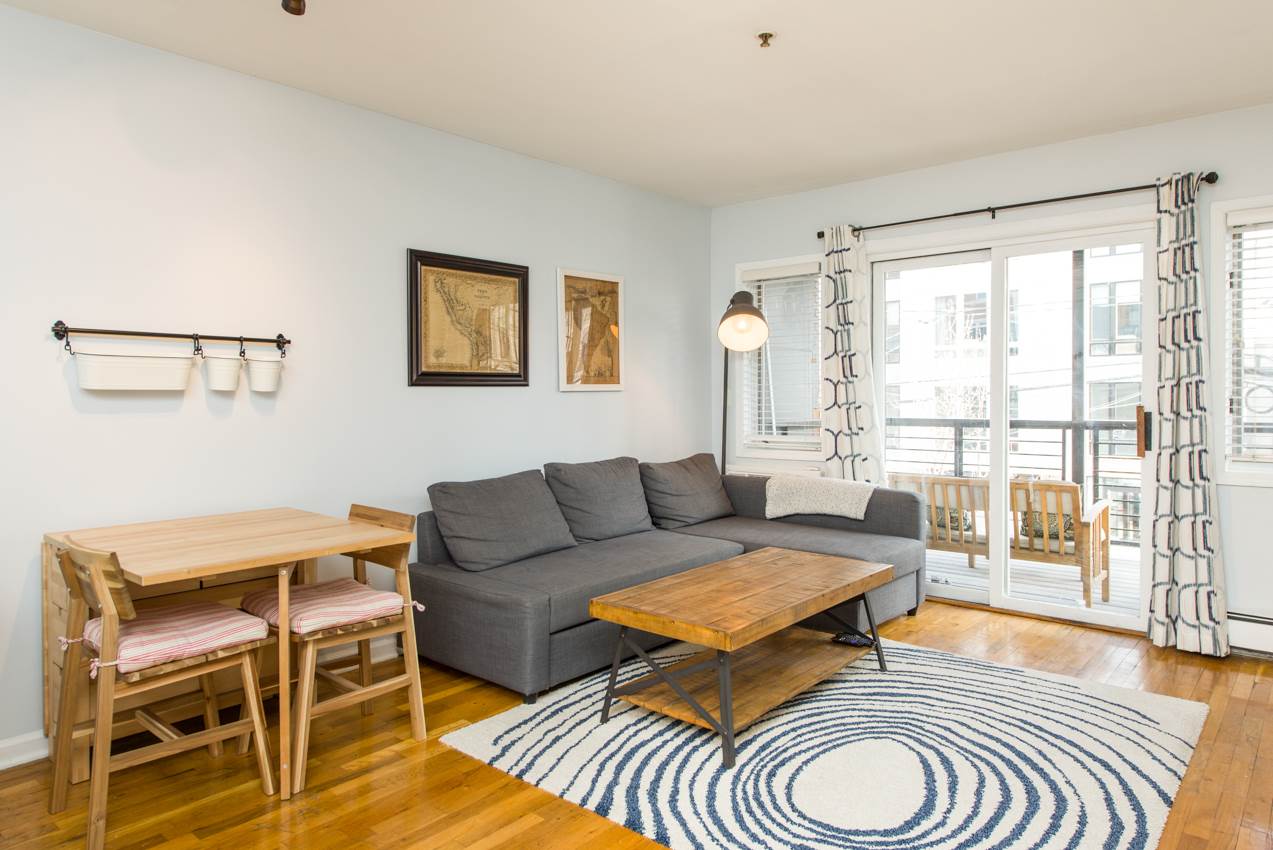 68 Monroe Street, Unit 2A Hoboken, NJ 07030 - Photo 1 of 1 a living room with furniture and a floor to ceiling window