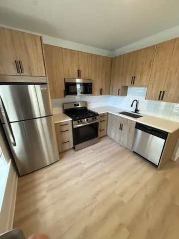 a kitchen with stainless steel appliances granite countertop a refrigerator sink and stove