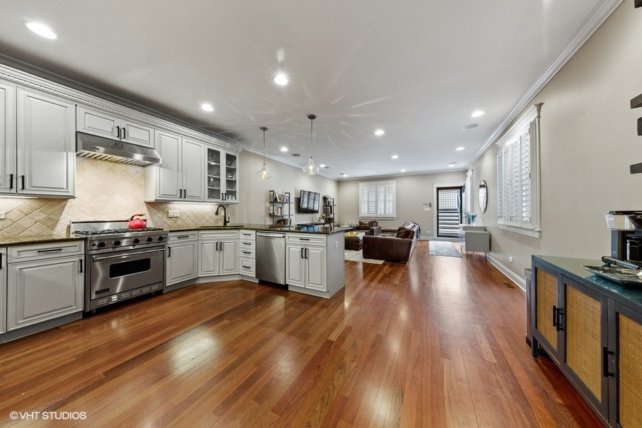 2248 North Racine Avenue, Unit 1 Chicago, IL 60614 - Photo 6 of 27 a kitchen with stainless steel appliances a stove a sink a refrigerator and white cabinets with wooden floor