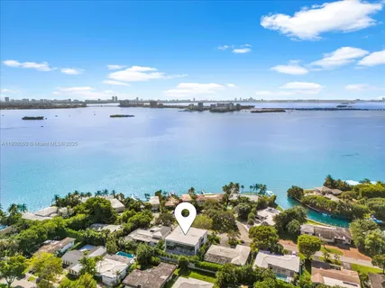 a living room with furniture large windows and wooden floor