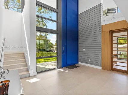 a view of a dining room with furniture large windows and a chandelier