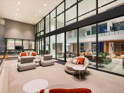 a living room with furniture a rug potted plant and a large window