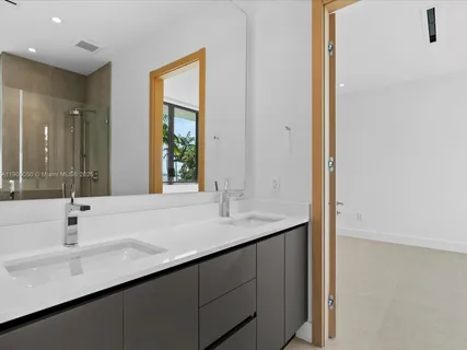 an aerial view of a residential houses with outdoor space and ocean view