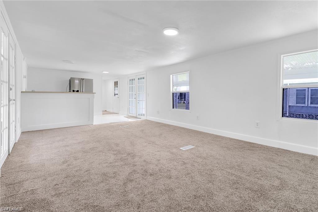 120 Grassy Key Lane, Unit 38 Naples, FL 34114 - Photo 8 of 28 a view of a big room with windows and chandelier