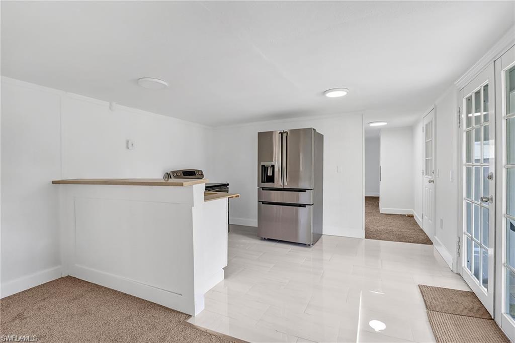 120 Grassy Key Lane, Unit 38 Naples, FL 34114 - Photo 9 of 28 a view of a kitchen with refrigerator stove and wooden floor